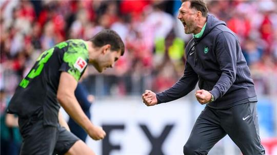 Wolfsburgs Trainer Ralph Hasenhüttl (r) jubelt nach dem Spiel mit Wolfsburgs Jonas Wind (l).