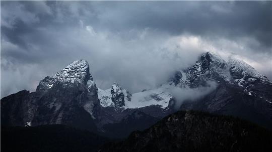 Wolkenverhangen ist der schneebedeckte Watzmann.