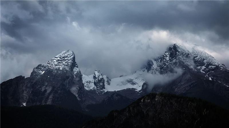 Wolkenverhangen ist der schneebedeckte Watzmann.
