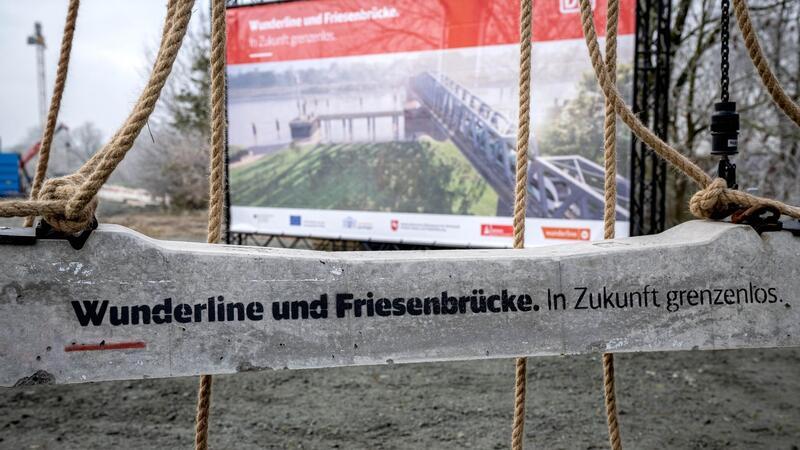Bahnlinie: Friesenbrücke und Wunderline später fertig „Wunderlinie und Friesenbrücke“ steht auf einer Bahnschwelle, die auf der neuen Bahnstrecke verbaut wird.