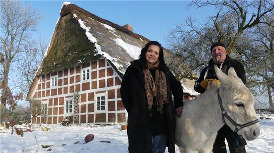 Yvonne und Thorsten Neumann vor der denkmalgeschützen Hofanlage Haus Siebenstein in Dornbuschermoor. Eselin Franzi gehört zu den Tieren des Tierschutzhofs, von denen etliche bei der tiergestützten Therapie zum Einsatz kommen.