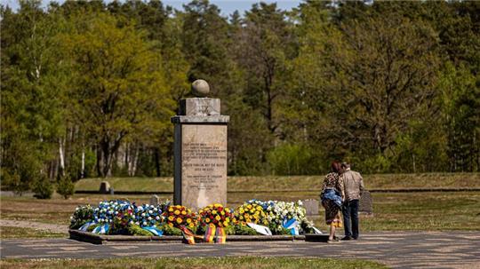 Zahlreiche Blumenkränze liegen um einen Gedenkstein auf dem Gelände der Gedenkstätte Bergen-Belsen.