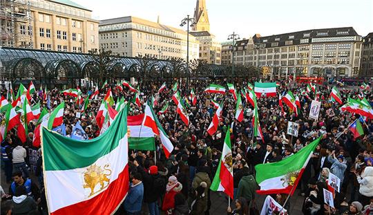 Zahlreiche Demonstranten mit Fahnen und Plakaten stehen zum Ende der Demonstration auf dem Rathausmarkt. Nach der Hinrichtung zwei weiterer Demonstranten im Iran sind in Hamburg mehr als 2000 Menschen auf die Straße gegangen, um gegen den repressiven Kurs der iranischen Regierung zu protestieren. Foto: Jonas Walzberg/dpa