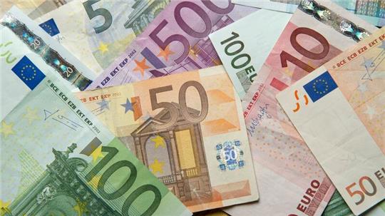 Zahlreiche Euro-Banknoten liegen auf einem Tisch.
