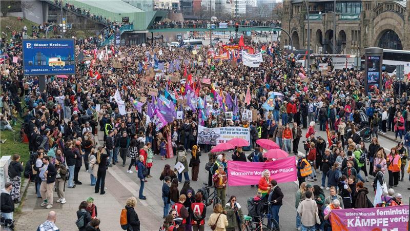 Zahlreiche Fahnen in Rot und Lila werden auf der feministischen Demonstration an den Landungsbrücken gezeigt.