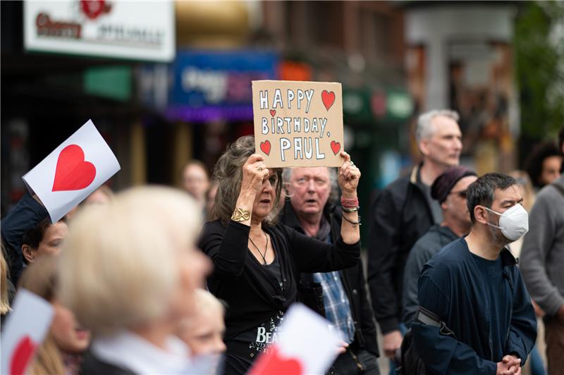 Zahlreiche Fans stehen während der Dreharbeiten zum Musikvideo der Band Salamanda auf dem Beatles-Platz in Hamburg. Foto: Daniel Reinhardt/dpa
