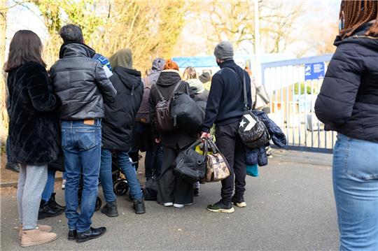 Zahlreiche Geflüchtete stehen in einer Schlange zur Registrierung am Ankunftszentrum Rahlstedt. . Foto: Jonas Walzberg/dpa