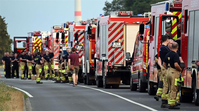Zahlreiche Kräfte der Feuerwehr stehen an einer Straße.
