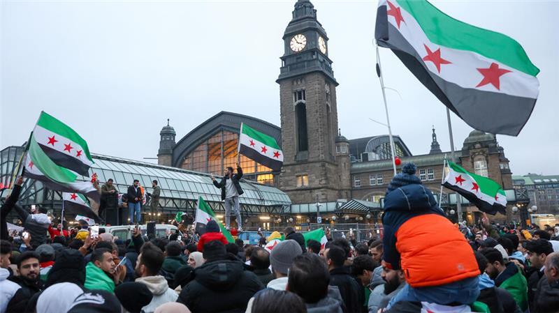 Zahlreiche Menschen feiern am Hachmannplatz den Sturz von Syriens Machthaber Assad.