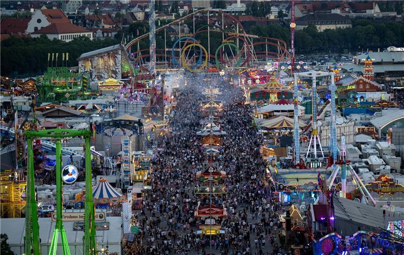 Zahlreiche Menschen laufen am ersten Tag der Wiesn über das Festgelände.