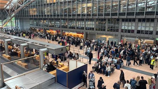 Zahlreiche Menschen stehen im Terminal des Hamburger Flughafens.