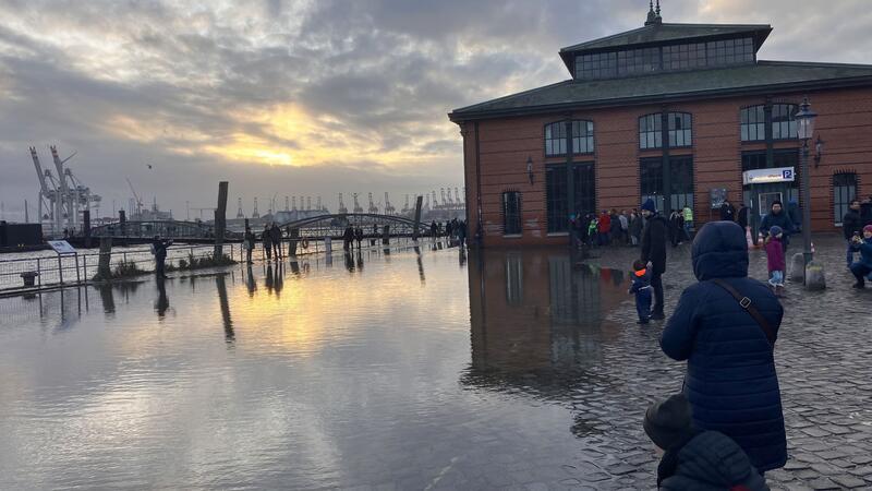 Sturmflut setzt Hamburger Fischmarkt erneut unter Wasser Zahlreiche Passanten und Spaziergänger sehen sich den leicht unter Wasser stehenden Fischmarkt an.