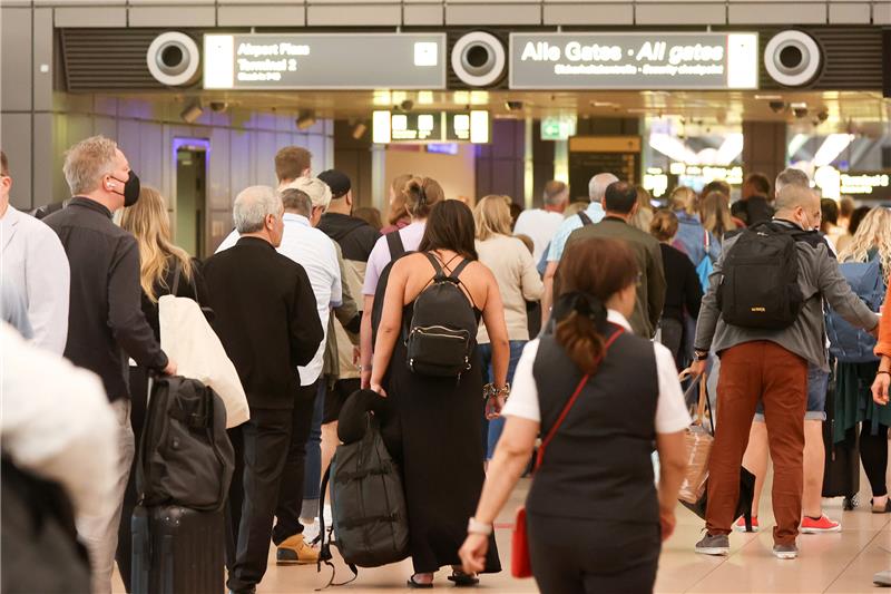 Zahlreiche Reisende warten am Morgen in Schlangen vor der Sicherheitskontrolle am Hamburger Flughafen. In Schleswig-Holstein haben die Sommerferien begonnen. Foto: Bodo Marks/dpa