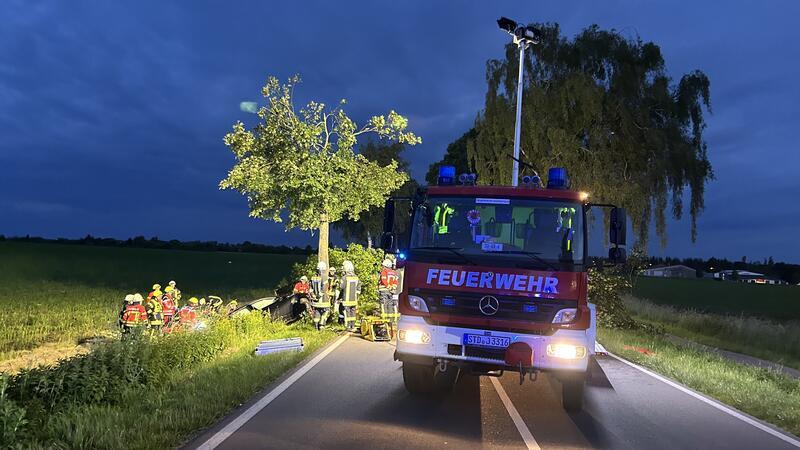 Autofahrer fährt in Harsefeld so heftig gegen Baum, dass Baumkrone abbricht Zahlreiche Rettungskräfte halfen vor Ort. Im Hintergrund der Baum ohne Baumkrone.