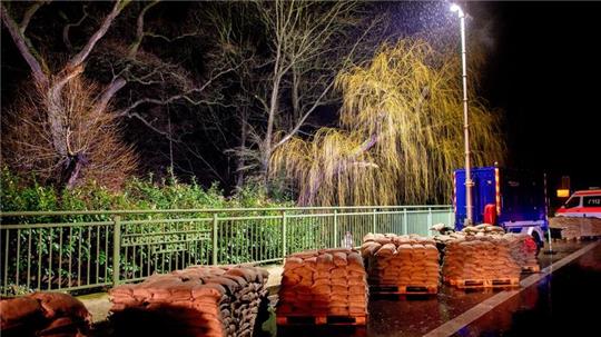 Zahlreiche Sandsäcke stehen auf einer Brücke.