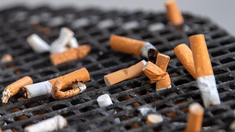 Deutliche Zunahme von Lungenkrebs in Schleswig-Holstein Zahlreiche Zigarettenstummel liegen in einem Aschenbecher vor einem Büro.