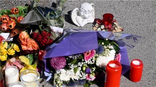 Zeichen der Anteilnahme: Auf einem Bürgersteig an dem Spielplatz sind Kerzen und Blumen niedergelegt worden.