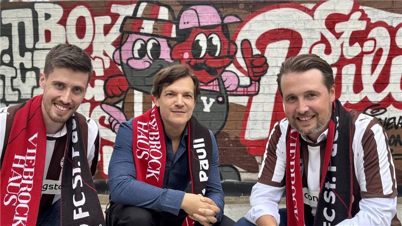 Zeichen der besonderen Zusammenarbeit: Die Brüder Lars Viebrock (links) und Dirk Viebrock aus Harsefeld mit FC-St.-Pauli-Manager Wilken Engelbracht vor der Zukunftswand.