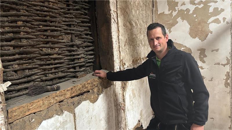 Zimmerermeister Fabian Timmann zeigt eine besondere Stelle am Fachwerk: Wie mit einem Korbgeflecht ist es ausgefüllt.