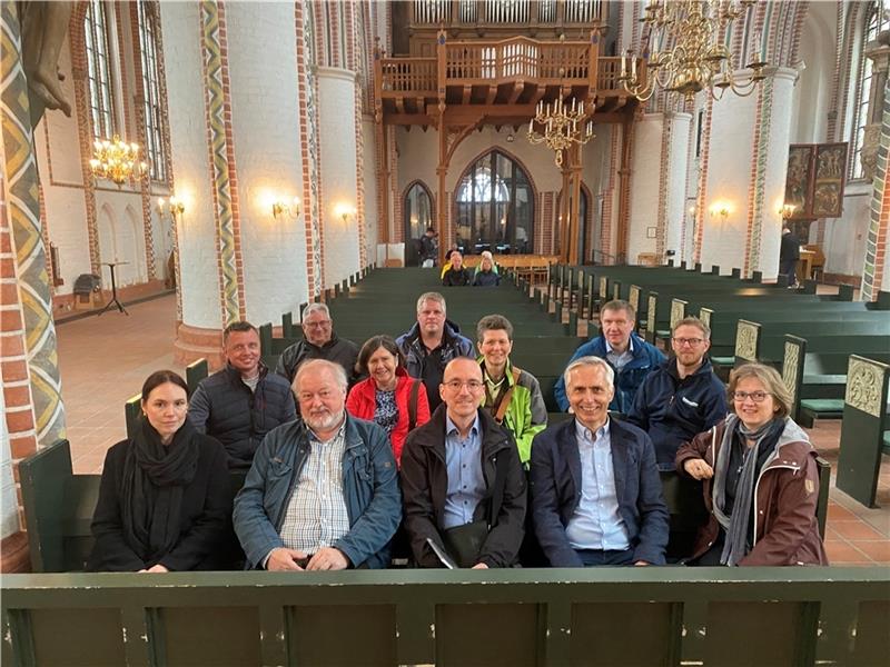 Zufriedene Gesichter bei der Bauabnahme im Kreis der Projektbeteiligten: Die neue Sitzheizung für die Kirchenbänke sorgt für angenehme Wärme. Foto: Weselmann