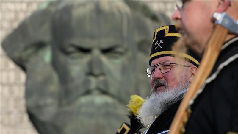 Zum Abschluss des Kulturhauptstadtjahres in Chemnitz ziehen Teilnehmer der Bergparade im traditionellen Habit am Karl-Marx-Monument vorbei. 
