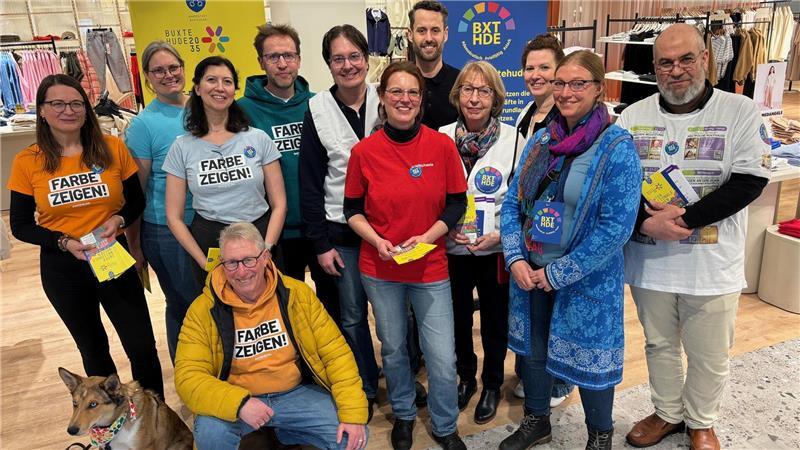 Zum Auftakt der Internationalen Wochen gegen Rassissmus in Buxtehude verteilen Ehrenamtliche vom Bündnis Buxtehude im Modehaus Stackmann Programmhefte. Hinten in Schwarz: Kaufhauschef Fabian Stackmann.