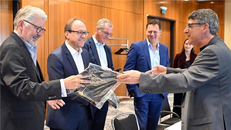 Zum Beginn der Tarifverhandlungen in der Stahlindustrie überreicht der Verhandlungsführer der IG Metall, Knut Giesler, zwei T-Shirts an den Verhandlungsführer der Arbeitgeber, Reiner Blaschek (2.v.l), sowie den Geschäftsführer des Arbeitgeberverbandes Stahl, Gerhard Erdmann (l).