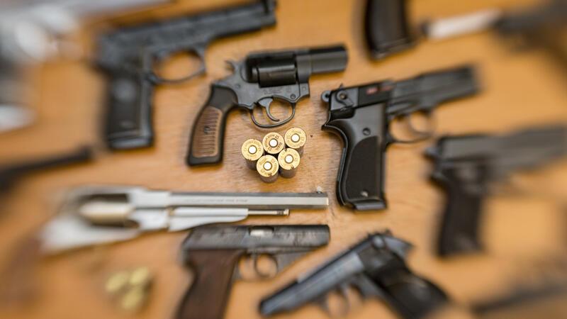 LKA Hamburg lagert Tausende Waffen Pistolen und Revolver und Munition liegen auf einem Tisch in einer gesicherten Asservatenkammer.