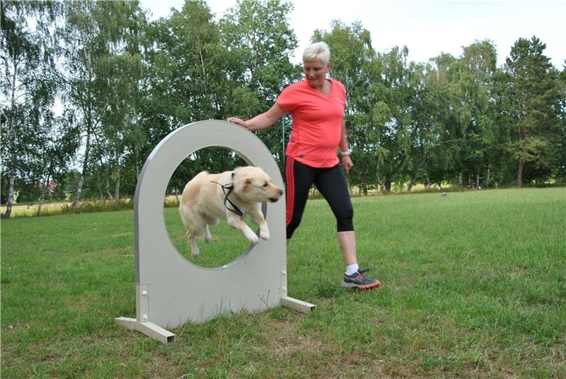 Zum Hindernisparcours bei den Best Buddy Games gehört auch der Sprung durch den Ring: Elke Sievers und ihre Labrador-Samojede-Hündin Ella zeigen, wie es geht. Fotos: Lohmann