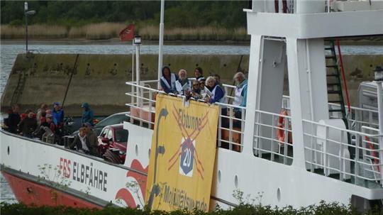 Zum Tag der Mobilitätswende hatten die A20-Gegner ein Banner außenbords der Elbfähre befestigt. Die Fährverbindung über die Elbe müsse ausgebaut werden, fordern sie.