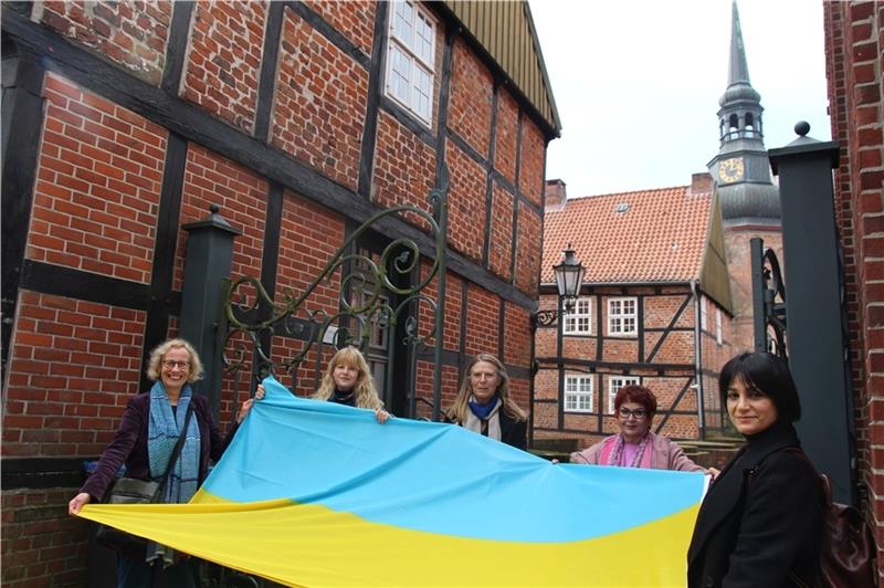 Zum Willkommen rollen sie vor dem Frauen- und Mütterzentrum die Flagge der Ukraine aus: Karina Holst (Hansestadt Stade), Gabi Siedentopf (Awo), Marlene Apmann (Soroptimist Club), Schole Albers (Frauen- und Mütterzentrum) und Berna Cumart (M