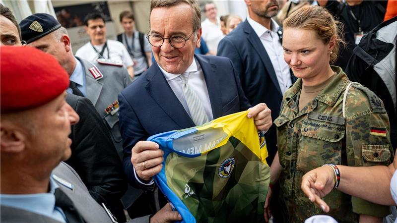 Zum erstmals 2025 begangenen Nationalen Veteranentag überreicht das Laufteam der Bundeswehr Verteidigungsminister Boris Pistorius ein Trikot beim Bürgerfest am Reichstagsgebäude