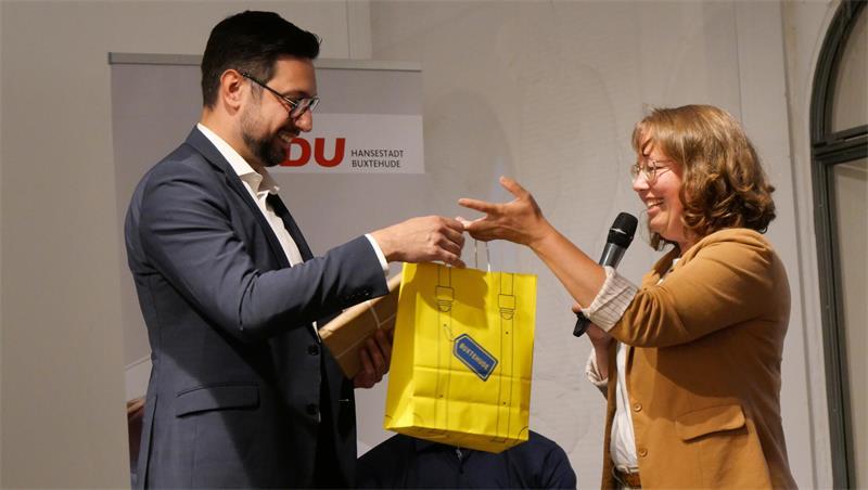 Zur Erinnerung an das „unheimlich schöne“ Buxtehude bekam André Yorulmaz unter anderem das mit dem Buxtehuder Bullen 2024 ausgezeichnete Buch „Der Tunnelbauer“ überreicht, in dem die düsteren Auswirkungen eines autoritären Staatswesens eindringlich thematisiert werden.