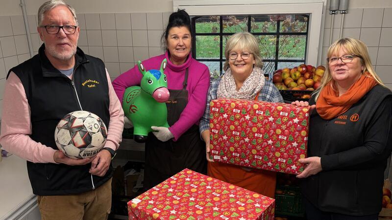 Zusätzlich zur Lebensmittelausgabe geben Ehrenamtliche der Buxtehuder Tafel bis 23. Dezember Weihnachtsgeschenke für bedürftige Kinder an die Eltern aus (von links): Tafel-Leiter Arno Weller mit den Helferinnen Heike Holst, Sigrid Harm-Raszpir und der stellvertretenden Tafel-Leiterin Elisabeth Freundel.