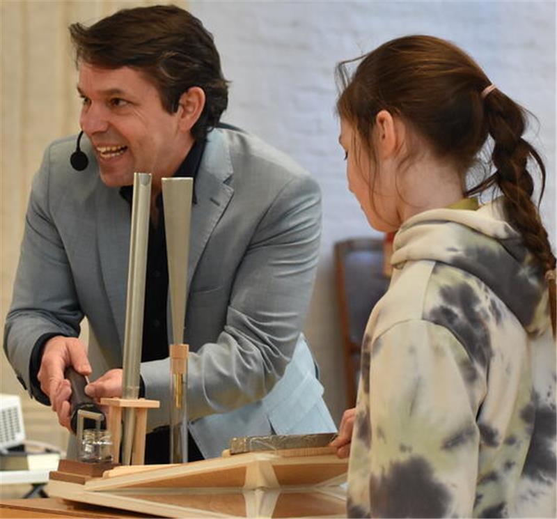 Zusammen mit einer Schülerin demonstriert Juri Tetzlaff an einem Blasebalg-Modell, warum Luft das entscheidende Element ist, um der Orgel Töne zu entlocken.