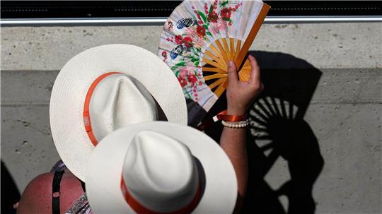 Zuschauer kühlen sich an einem heißen Tag mit Handfächern bei den Tennis French Open.