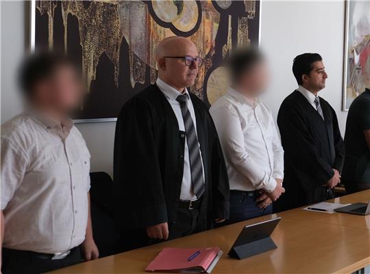Zwei Angeklagte mit ihren Anwälten Cem Kilic (2.v.l.) und Zubair Khan (r) im Gerichtssaal in Lünen.