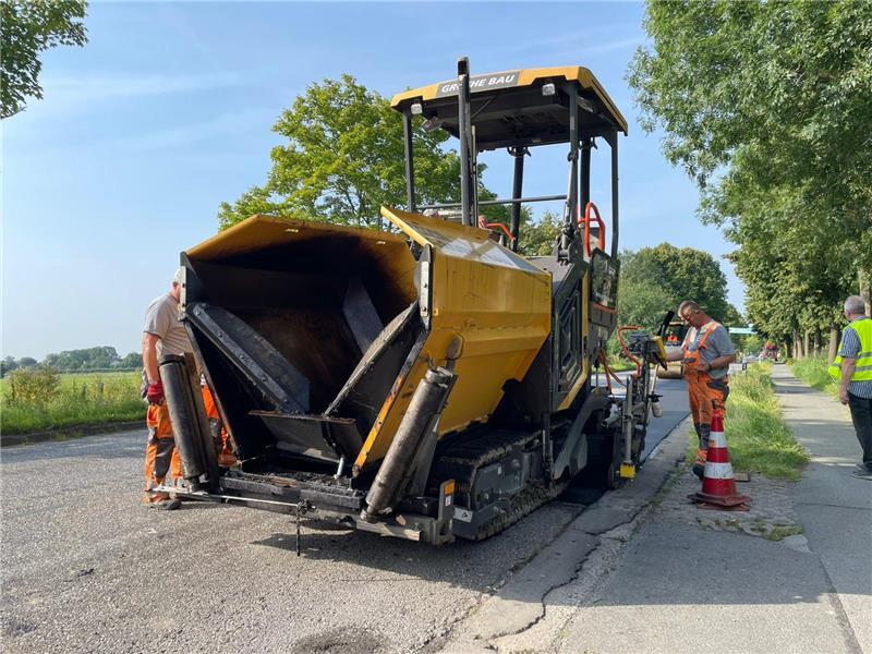 170 Grad: So gehen Straßenbauarbeiter in Stade mit der Hitze um Zwei Bauarbeiter bedienen einen Aspahltfertiger.