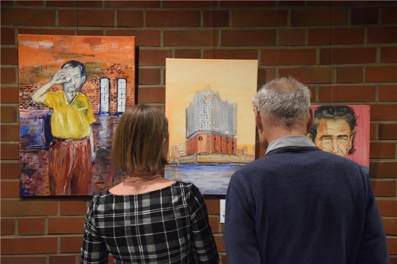 Zwei Besucher betrachten die Kunstwerke der „Aktiven Kunstschaffenden“ im Rathaus Neu Wulmstorf. Fotos: Battmer