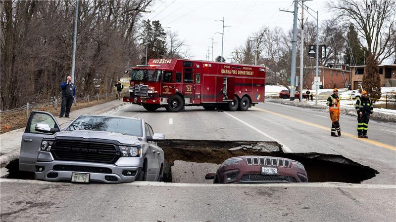 Zwei Fahrzeuge liegen auf der Pacific Street östlich der 67th Street in Omaha in einem Sinkloch.