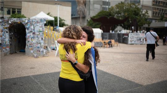 Zwei Israelis umarmen sich, während sich Menschen auf dem Geiselplatz in Tel Aviv versammeln, um das Waffenstillstandsabkommen zu feiern.