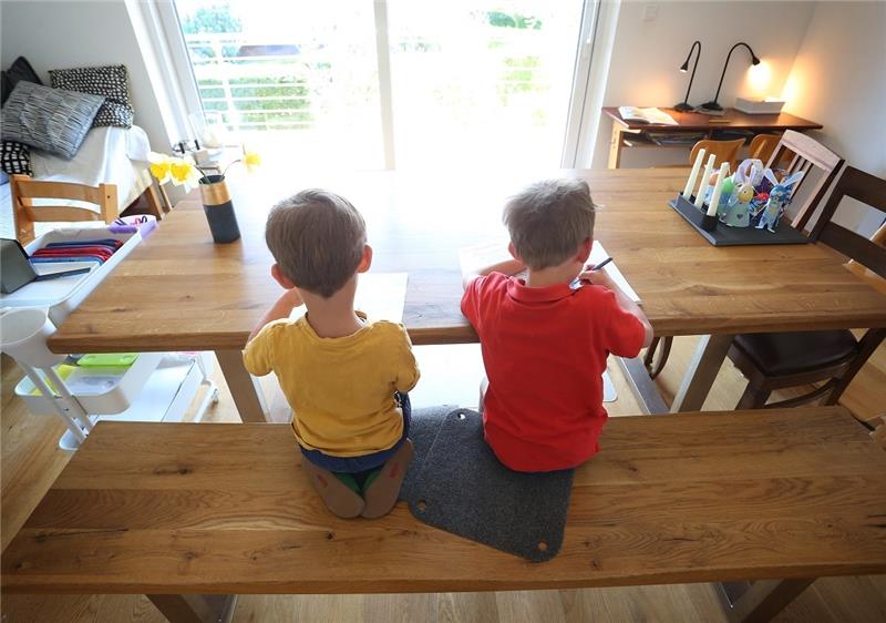 Zwei Junge füllen zu Hause im Lockdown Lernbücher aus (Symbolbild). Foto: Karl-Josef Hildenbrand/dpa