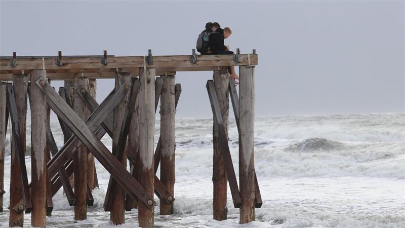 Zwei Jungen beobachten auf der Insel Norderney von oben die stürmischen Wellen.