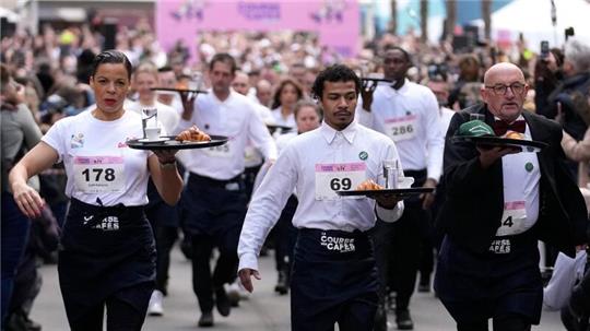 Zwei Kilometer ohne zu rennen und ohne etwas zu verschütten: Dieser Aufgabe stellen sich Kellnerinnen und Kellner in Paris.