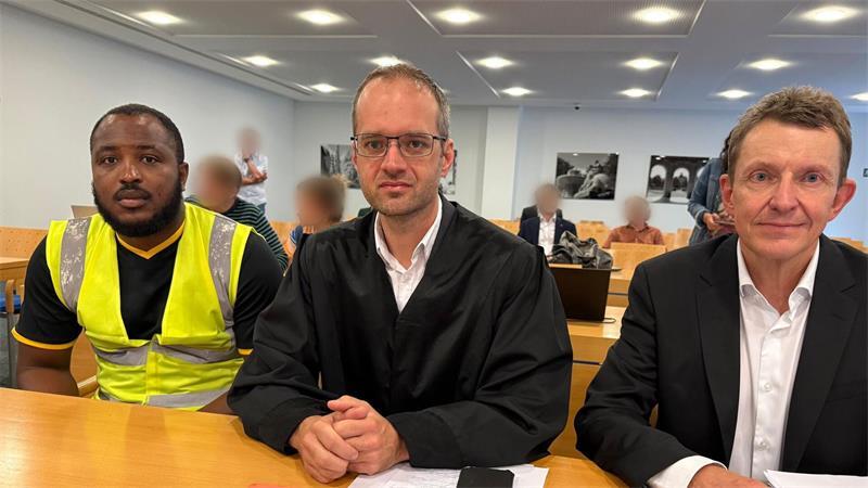 Trotz Urteil: Betroffene müssen Kontrollen weiter dulden Zwei Kläger mit ihrem Anwalt (M). (Archivbild)