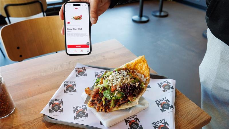 Zwei Mal Krispy Kebab: einmal auf dem Smartphone in der KFC-App und einmal auf einem Tablett in einer Krispy-Kebab-Filiale.