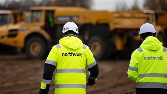 Zwei Mitarbeiter der Firma Northvolt gehen über eine Baustelle im Kreis Dithmarschen.
