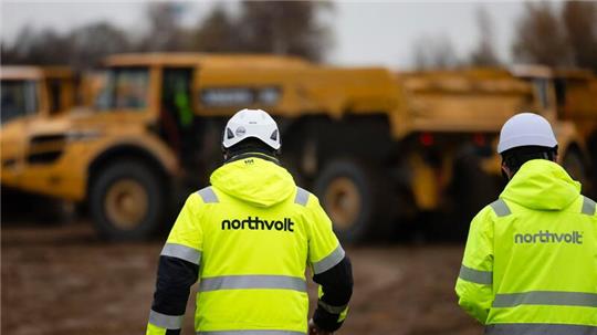 Zwei Mitarbeiter der Firma Northvolt gehen über eine Baustelle im Kreis Dithmarschen.