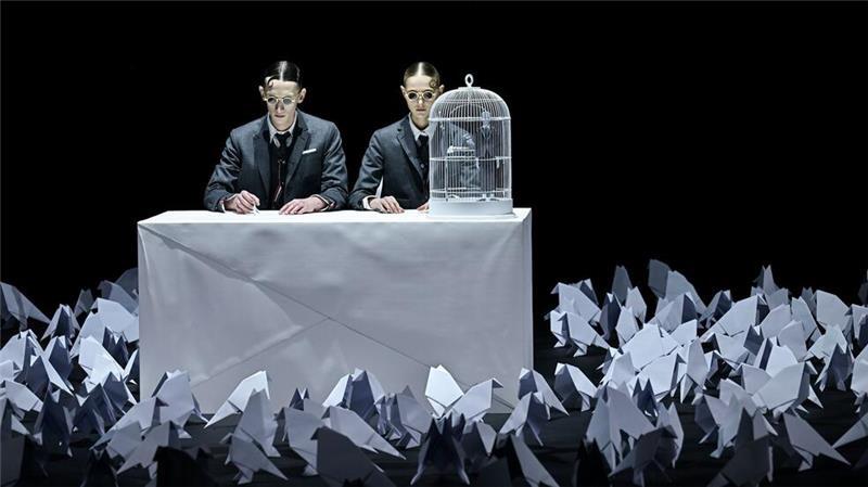 Zwei Models sitzen an einem Tisch auf dem Laufsteg während der Thom Browne Herbst/Winter 2025 Modenschau im Rahmen der New York Fashion Week.