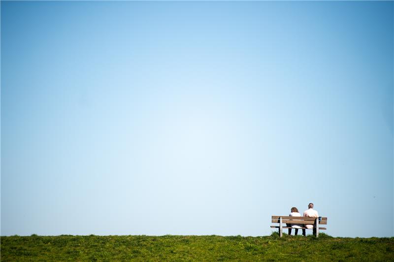 Zwei Personen sitzen auf einer Bank. Foto: Jonas Güttler/dpa
